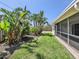 Landscaped backyard featuring lush tropical plants and a screened-in patio at 5331 Citadel Rd, Venice, FL 34293