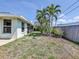 View of the home's backyard with lush landscaping, fencing, and an outdoor patio area at 5331 Citadel Rd, Venice, FL 34293