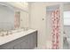 Bathroom featuring a gray vanity with double sinks, a large mirror, and a shower with a floral curtain at 5331 Citadel Rd, Venice, FL 34293