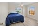 Bright bedroom featuring light-colored floors, two windows, and a comfortable bed with blue bedding at 5331 Citadel Rd, Venice, FL 34293