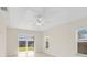 Bright bedroom featuring light-colored floors, a ceiling fan, and a sliding glass door to the backyard at 5331 Citadel Rd, Venice, FL 34293