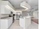 Modern kitchen with stainless steel appliances, white cabinets, breakfast bar, and tile flooring at 5331 Citadel Rd, Venice, FL 34293