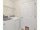 Bright laundry room with white washer and dryer, storage shelves, and a white door at 5331 Citadel Rd, Venice, FL 34293