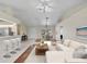 Staged living area with a couch, dining table, and breakfast bar with modern white counter stools at 5331 Citadel Rd, Venice, FL 34293
