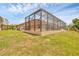 Spacious backyard featuring a concrete screened-in pool and manicured lawn at 8183 Deland St, Port Charlotte, FL 33981