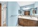 Bathroom featuring double vanity with quartz countertop, wood cabinets, and tiled backsplash at 8183 Deland St, Port Charlotte, FL 33981