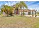 Inviting two-story home with a lush lawn and mature palm trees, offering curb appeal and Florida charm at 8183 Deland St, Port Charlotte, FL 33981
