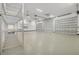 Expansive three car garage offering high ceilings, polished floors, and metal storage racks at 8183 Deland St, Port Charlotte, FL 33981