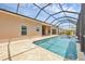 Inviting screened-in pool boasts clear water and a relaxing patio area with travertine tile at 8183 Deland St, Port Charlotte, FL 33981