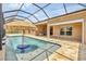 The inviting screened-in pool includes a sunshade umbrella table and a relaxing sun shelf at 8183 Deland St, Port Charlotte, FL 33981
