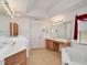 Bright bathroom with dual sinks, vanity area, soaking tub, and ample storage space at 8377 Mambo Ave, North Port, FL 34291