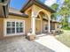 Close-up of the beige home's front entrance, showcasing the elegant archway and paver walkway at 8377 Mambo Ave, North Port, FL 34291
