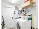 Efficient laundry room with washer, dryer, storage shelves, and convenient access to an exterior door at 8377 Mambo Ave, North Port, FL 34291