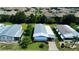Overhead view of the property with a lush lawn, mature trees, and covered parking at 857 Seabrooke Dr, Englewood, FL 34223