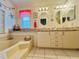 Bathroom featuring double sinks, a tub, and decorated with a charming nautical theme at 857 Seabrooke Dr, Englewood, FL 34223
