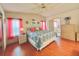 Bedroom with hardwood floors, a patterned comforter, decorative wall art, and natural light from the windows at 857 Seabrooke Dr, Englewood, FL 34223