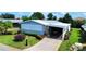 Well-kept home with lush landscaping, a covered carport, and an inviting driveway at 857 Seabrooke Dr, Englewood, FL 34223