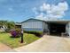 Inviting home featuring a carport, lush landscaping, and colorful flowers, creating a welcoming curb appeal at 857 Seabrooke Dr, Englewood, FL 34223