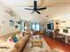 Cozy living room featuring a ceiling fan, comfortable seating, and a seamless flow to the adjacent kitchen at 857 Seabrooke Dr, Englewood, FL 34223