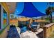 Backyard patio featuring a blue sun shade over an outdoor table with seating and landscaping at 900 Stewart St, Englewood, FL 34223