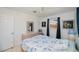 This bedroom contains a queen bed, wood furniture, blue curtains, and updated windows at 900 Stewart St, Englewood, FL 34223