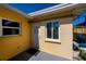 Yellow home exterior featuring windows with yellow trim, a white door, and an outdoor mat at 900 Stewart St, Englewood, FL 34223