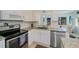 Modern kitchen featuring white cabinets, stainless steel appliances, and granite countertops, with an adjoining dining area at 900 Stewart St, Englewood, FL 34223