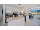 Well-lit kitchen with white cabinets, stainless steel appliances, granite countertops, and an adjacent dining area at 900 Stewart St, Englewood, FL 34223