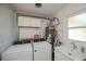 This laundry room includes a washer and dryer, cabinets, utility sink, and water heater at 900 Stewart St, Englewood, FL 34223