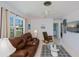 Cozy living room with a comfortable leather sofa, neutral walls, large window and ceiling fan at 900 Stewart St, Englewood, FL 34223