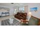 Charming living room with a leather sofa, bright window views, and easy access to the front entry at 900 Stewart St, Englewood, FL 34223