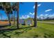 Yard with a yellow shed with a blue stripe above the door at 900 Stewart St, Englewood, FL 34223