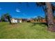 Large lot with a yellow home, a wooden deck, and a large manicured yard at 900 Stewart St, Englewood, FL 34223