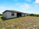 Expansive backyard featuring lush grass and a view of the property's exterior at 97 Pine Valley Ln, Rotonda West, FL 33947