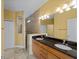 Bathroom with double sinks, granite countertop, and tiled walk-in shower at 97 Pine Valley Ln, Rotonda West, FL 33947