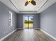Bright bedroom with wood floors, a tray ceiling, and sliding glass doors to the backyard at 97 Pine Valley Ln, Rotonda West, FL 33947