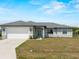 Charming single-story home featuring a two-car garage, neutral colors, and a well-manicured lawn at 97 Pine Valley Ln, Rotonda West, FL 33947