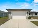 Spacious two-car garage with white door and concrete driveway of a well-maintained home at 97 Pine Valley Ln, Rotonda West, FL 33947