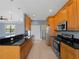 Spacious kitchen featuring wooden cabinets, stainless steel appliances and a breakfast bar at 97 Pine Valley Ln, Rotonda West, FL 33947