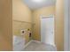 Functional laundry room with a utility sink, storage shelves, and tile floor at 97 Pine Valley Ln, Rotonda West, FL 33947
