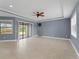 Large living room with fan, neutral tile floors, sliding glass doors and abundant natural light at 97 Pine Valley Ln, Rotonda West, FL 33947