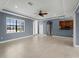 Spacious living room with tray ceilings, fan, large windows, neutral tile floors and open floorplan at 97 Pine Valley Ln, Rotonda West, FL 33947