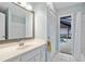Bathroom with a sink and mirror with a doorway leading out to the backyard pool at 1 Sportsman Way, Rotonda West, FL 33947