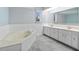 Bathroom featuring a soaking tub, double sink vanity, and ample counter space at 1 Sportsman Way, Rotonda West, FL 33947