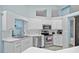 Bright kitchen features white cabinets, stainless steel appliances, and natural light through a window at 1 Sportsman Way, Rotonda West, FL 33947