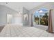 Bright living room with tile flooring, a high ceiling, and arched windows with views of the yard at 1 Sportsman Way, Rotonda West, FL 33947