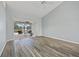 Spacious living room featuring wood flooring that leads to a sliding door and screened-in pool area at 1 Sportsman Way, Rotonda West, FL 33947
