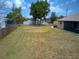 A large green backyard bordered with a fence on a sunny day at 10112 Willmington Blvd, Englewood, FL 34224