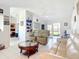 Bright living room with tile flooring, ceiling fan, white leather sofas, and easy access to the kitchen and outdoor patio at 10112 Willmington Blvd, Englewood, FL 34224