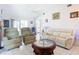 Comfortable living room with vaulted ceilings, a ceiling fan, tile floors, white sofas, and views of the dining area at 10112 Willmington Blvd, Englewood, FL 34224